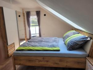 een bed met kussens in een kamer bij Ferienwohnung Schertel - Dorsbrunn in Pleinfeld