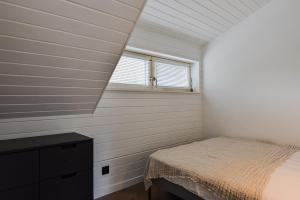 um quarto com uma cama e uma janela em Fisheria Apartamentai em Preila