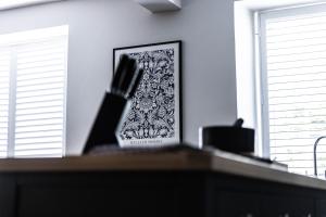 a picture on a desk in a room with two windows at The Unicorn (Apartments) in Stow on the Wold