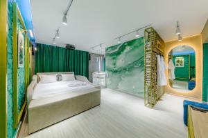 1 dormitorio con cama y pared verde en Квартира-студия c домашним кинотеатром Ocean, en Petropavlovsk