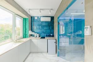 La salle de bains est pourvue d'un lavabo et d'une douche. dans l'établissement Квартира-студия c домашним кинотеатром Ocean, à Petropavlovsk-Kamtchatski