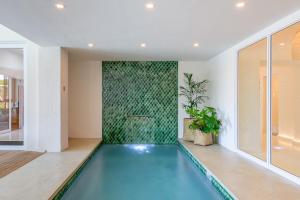 an indoor swimming pool in a house with a green wall at San Lameer Villa 3117 - 3 Bedroom Superior - 6 pax - San Lameer Rental Agency in Southbroom