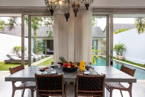 a dining room with a table with a bowl of fruit on it at Villa Mia in Canggu