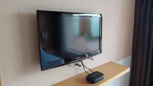 TV de pantalla plana colgada en la pared en Mysore County Retreat, en Mysore