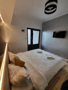 una camera da letto con un grande letto bianco con cuscini di Casa Mina Divici a Divici