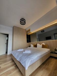 ein Schlafzimmer mit einem großen Bett mit zwei Geschirr darauf in der Unterkunft Casa Mina Divici in Divici