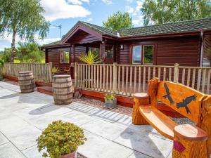 a wooden cabin with a bench in front of it at Red Kite Cottage in Tore