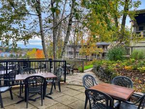 an outdoor patio with tables and chairs and trees at Inn at the Falls in Bracebridge