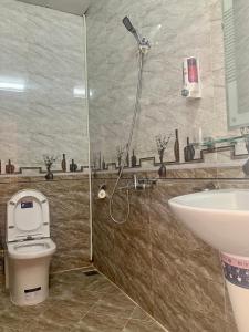 a bathroom with a shower and a toilet and a sink at Mi Casa Homestay in Da Lat