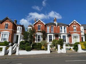 uma grande casa de tijolos vermelhos com janelas brancas em Anne’s House em Hastings