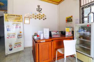a restaurant with a counter and a table and chairs at OYO 91607 Steze Guest House Syariah in Jambi