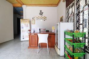 - une cuisine avec un comptoir et une chaise dans une pièce dans l'établissement OYO 91607 Steze Guest House Syariah, à Jambi