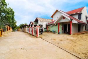 a row of houses on a dirt road at OYO 91607 Steze Guest House Syariah in Jambi