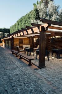 a pavilion with benches and tables on a patio at Tenuta Un Posto Al Sole Luxury B&B in Rossano Stazione