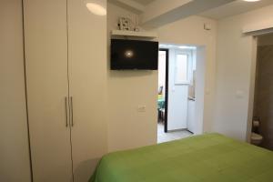 1 dormitorio con 1 cama y TV en la pared en Apartments KOMEL I, en Opatija