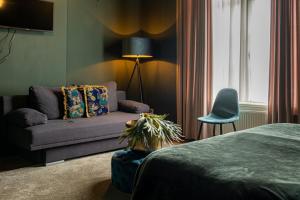 a living room with a couch and a bed at Hotel La Casa in Valkenburg