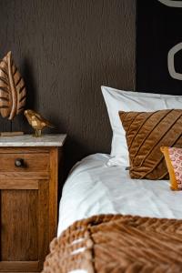 a bedroom with a bed and a nightstand with a bird on it at Hotel La Casa in Valkenburg