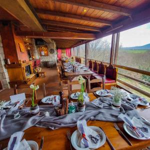 una lunga sala da pranzo con un lungo tavolo con piatti e tovaglioli di Metohi a Marioláta