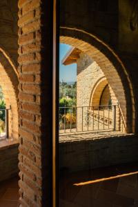 a window in a brick wall with a view of a balcony at Tenuta Un Posto Al Sole Luxury B&B in Rossano Stazione