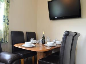uma mesa de madeira com cadeiras e uma garrafa de vinho em The Racecourse Lodge em Hexham