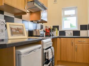 uma cozinha com um lavatório e um fogão forno superior em The Racecourse Lodge em Hexham
