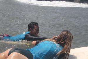 un hombre y una mujer tirados en el agua en Surfers Villa and Resorts Medewi, en Jembrana