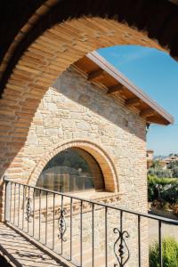 an archway in a stone building with a fence at Tenuta Un Posto Al Sole Luxury B&B in Rossano Stazione