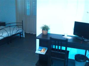 a room with a desk with a television and a chair at B&B Largo Barile in Caltanissetta