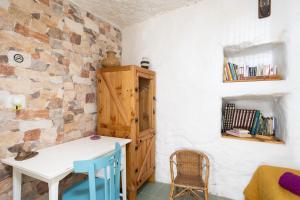 Habitación con mesa blanca y armario de madera. en Casa Cueva Gaspara en Lomo de Arico