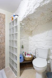 a bathroom with a toilet and a white wall at Casa Cueva Gaspara in Lomo de Arico