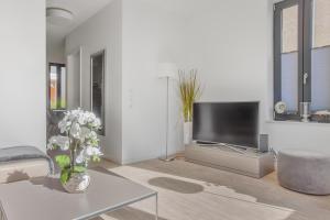 a living room with a television and a vase of flowers at Ostsee Perle 35 in Heiligenhafen
