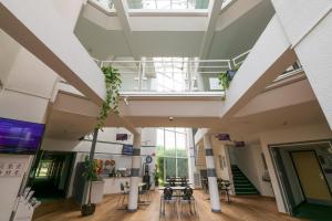 un hall vide d'un hôpital avec des tables et des chaises dans l'établissement Hôtel Cerise Auxerre, à Monéteau