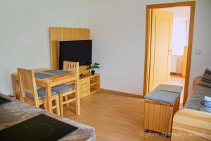 a living room with a table and a dining room at Aviatik apartmány in Jeseník