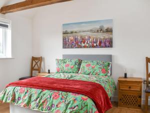 a bedroom with a bed and a painting on the wall at Chapel Farm Barn in Smeeth