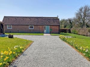 a brick house with a driveway in front of it at Chapel Farm Barn in Smeeth