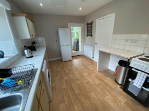 a kitchen with a white refrigerator and a wooden floor at South Lodge - Uk31880 in Newton Stewart