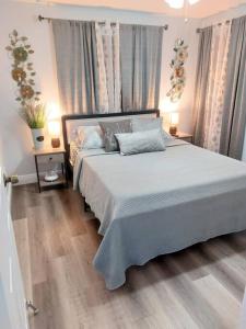 1 dormitorio con 1 cama blanca grande y 2 mesas en Torres Tiny Home Midtown WestTampa RJS, en Tampa