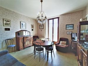uma sala de estar com uma mesa e cadeiras e um lustre em Appartement Aix-les-Bains, 2 pièces, 2 personnes - FR-1-555-48 em Aix-les-Bains