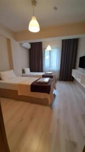 een grote slaapkamer met 2 bedden en een groot raam bij Moda Hotel in Kırklareli