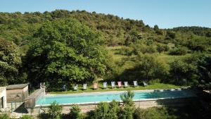 a swimming pool with chairs and umbrellas at Domaine De La Grange Neuve in La Roque-sur-Pernes
