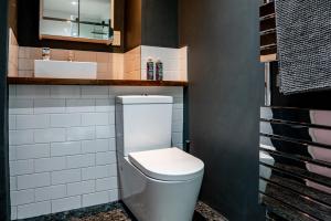 a bathroom with a white toilet and a sink at The Colour House Lake District Escape for Two in Kendal