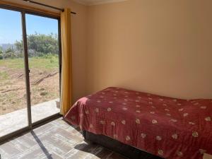 a bedroom with a bed and a large window at Casa de campo, con hermosa vista al mar in Tongoy