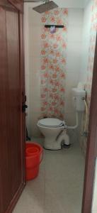 a bathroom with a toilet and a wall with flowers at Athalia guesthouse in Rishīkesh