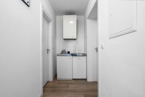 a kitchen with white cabinets and a sink at Apartment 5, direkt am Bahnhof in Aachen