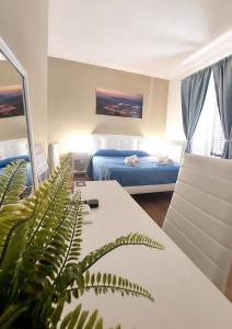 a room with a bed and a table with a plant at GUEST HOUSE PIANA DEGLI ALBANESI in Piana degli Albanesi