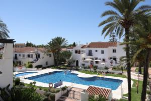 vista aerea su una piscina del resort con palme di Casa Alegría - Family home 1 km from Marbella Center a Marbella