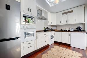 a kitchen with white cabinets and a washer and dryer at Casa Alegría - Family home 1 km from Marbella Center in Marbella