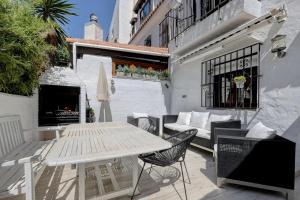 un patio con tavolo, sedie e camino di Casa Alegría - Family home 1 km from Marbella Center a Marbella