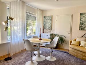 ein Wohnzimmer mit einem Tisch, Stühlen und einem Sofa in der Unterkunft Ferienwohnung Louise 50 m zum See in Kressbronn am Bodensee