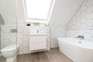 a bathroom with a toilet and a sink and a tub at Captivating 4-Bed House in Killin in Killin